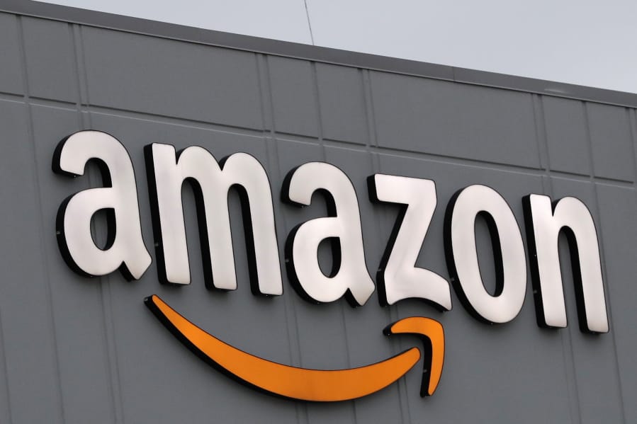 A sign is lit on the facade of an Amazon fulfillment center, Thursday, March 19, 2020, on Staten Island in New York. The company plans to hire another 100,000 new workers in their fulfillment centers to fill increased customer demand during the coronavirus outbreak in which many workers are working from home an discouraged from going out.