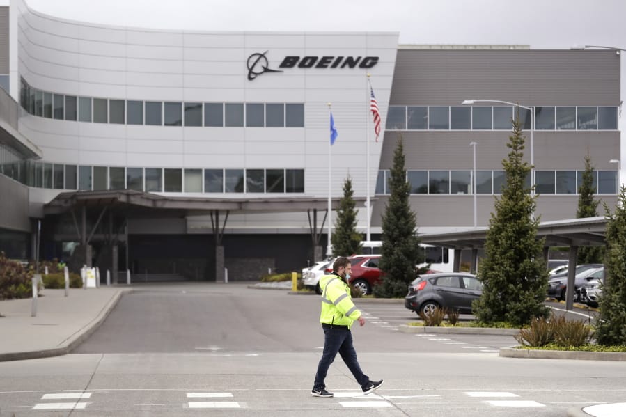 A worker walks at a Boeing production plant Tuesday, April 21, 2020, in Everett, Wash. Boeing this week is restarting production of commercial airplanes in the Seattle area, putting about 27,000 people back to work after operations were halted because of the coronavirus.