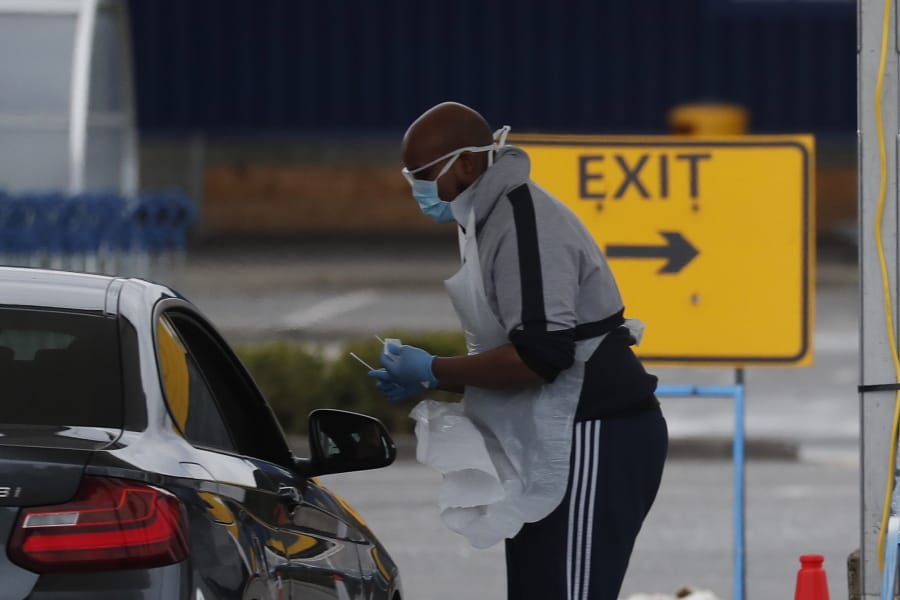 National Health Service staff wait in their cars to take a coronavirus test at a drive through centre in north London, Wednesday, April 1, 2020.
