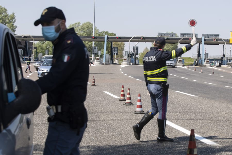 Police officers stop cars at the Melegnano highway barrier entrance, near Milan, Italy, Saturday, April 11, 2020. Using helicopters, drones and stepped-up police checks to make sure Italians don&#039;t slip out of their homes for the Easter holiday weekend, Italian authorities are doubling down on their crackdown against violators of the nationwide lockdown decree. The new coronavirus causes mild or moderate symptoms for most people, but for some, especially older adults and people with existing health problems, it can cause more severe illness or death.