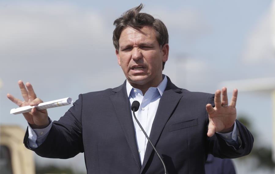 FILE - In this March 30, 2020, file photo Florida Gov. Ron DeSantis speaks during a news conference at a drive-through coronavirus testing site in front of Hard Rock Stadium in Miami Gardens, Fla.