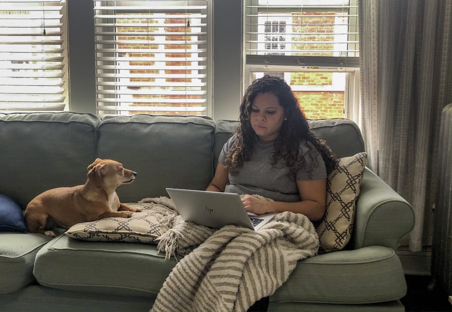 Vicktery Zimmerman works from her home Friday in Chicago during the coronavirus-related order to shelter in place. A self-proclaimed extrovert, Zimmerman has come up with workarounds like video calls to help herself deal with the lack of social interaction.