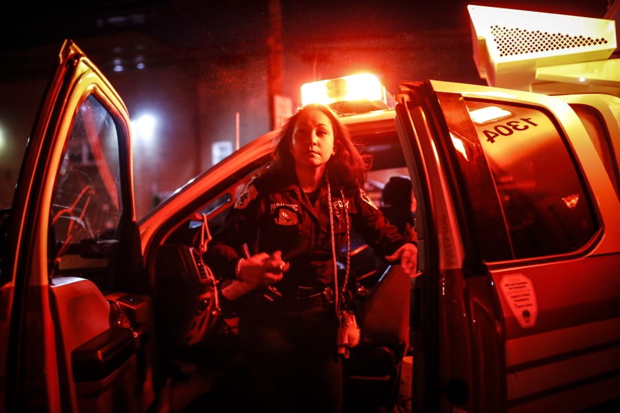 FDNY paramedic Elizabeth Bonilla sprays herself with disinfectant after responding to an emergency call during the coronavirus outbreak Wednesday, April 15, 2020, in the Bronx borough of New York. &quot;Emotionally, you have to be strong for the families that are going through it,&quot; she said. &quot;You don&#039;t want to cry in front of them.