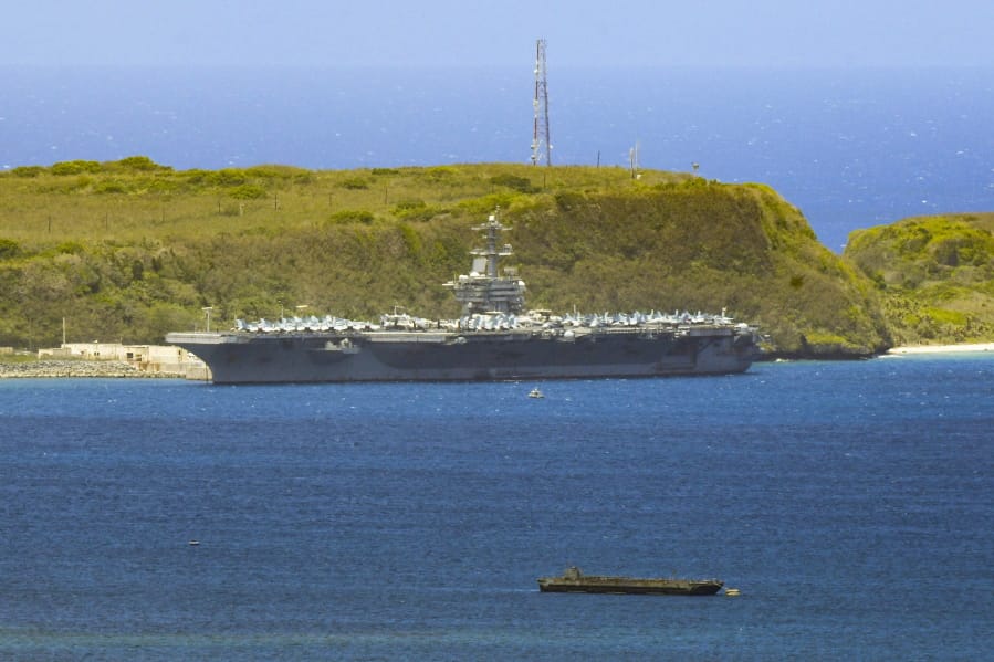 FILE - In this April 3, 2020, file photo, the USS Theodore Roosevelt, a Nimitz-class nuclear powered aircraft carrier, is docked along Kilo Wharf of Naval Base Guam. People in Guam are used to a constant U.S. military presence on the strategic Pacific island, but some are nervous as hundreds of sailors from the coronavirus-stricken Navy aircraft carrier flood into hotels for quarantine. Officials insist they have enforced strict safety measures.