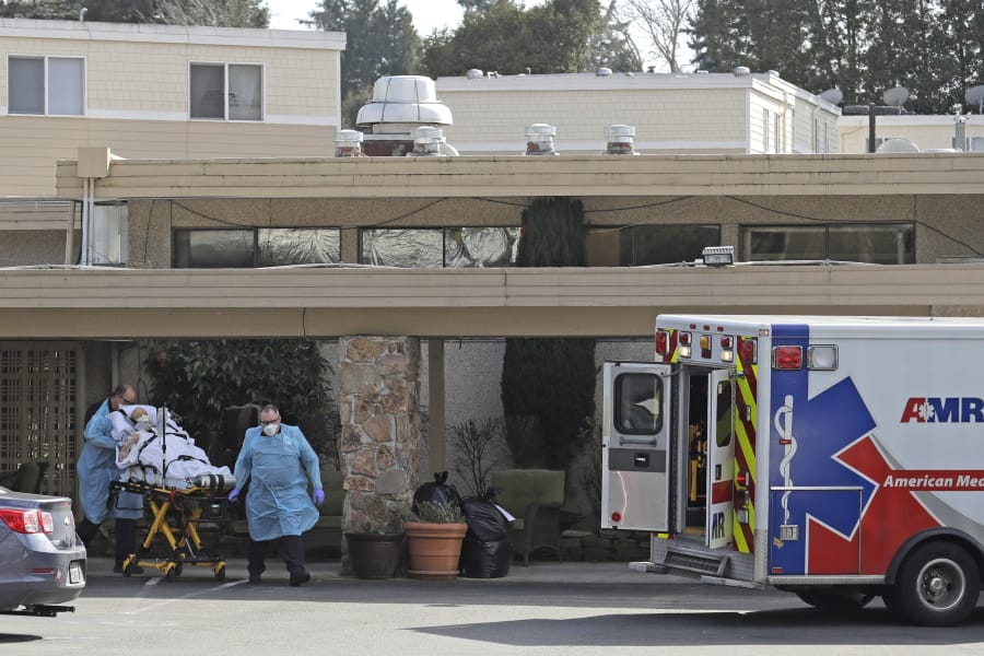 A person is loaded into an ambulance at Life Care Center in Kirkland, which has been at the center of the COVID-19 coronavirus outbreak in the state. Residents of assisted living facilities and their loved ones are facing a grim situation as the coronavirus spreads across the country, placing elderly people especially at risk. (AP Photo/Ted S.