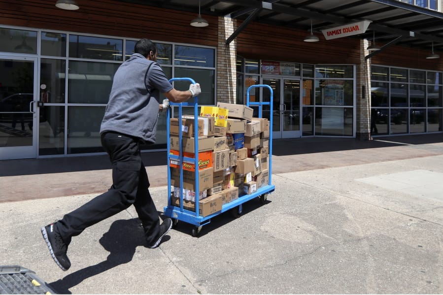 Cameron Webb, an employee with McLane Company, makes a delivery to a Family Dollar in Dallas, Wednesday, April 15, 2020.