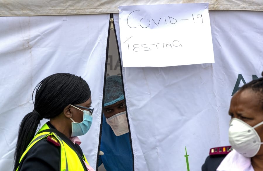 A health worker wearing personal protective gear inside a testing tent, gestures colleagues during the screening and testing for COVID-19, in Lenasia, south of Johannesburg, South Africa, Wednesday, April 8, 2020. South Africa and more than half of Africa&#039;s 54 countries have imposed lockdowns, curfews, travel bans or other restrictions to try to contain the spread of COVID-19. The new coronavirus causes mild or moderate symptoms for most people, but for some, especially older adults and people with existing health problems, it can cause more severe illness or death.