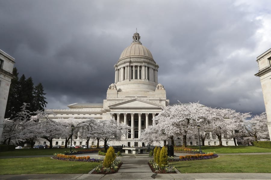 Cherry trees bloom next to the Capitol building March 23 in Olympia. The coronavirus&#039;s effect on state revenues is expected to be felt for months and maybe years to come.