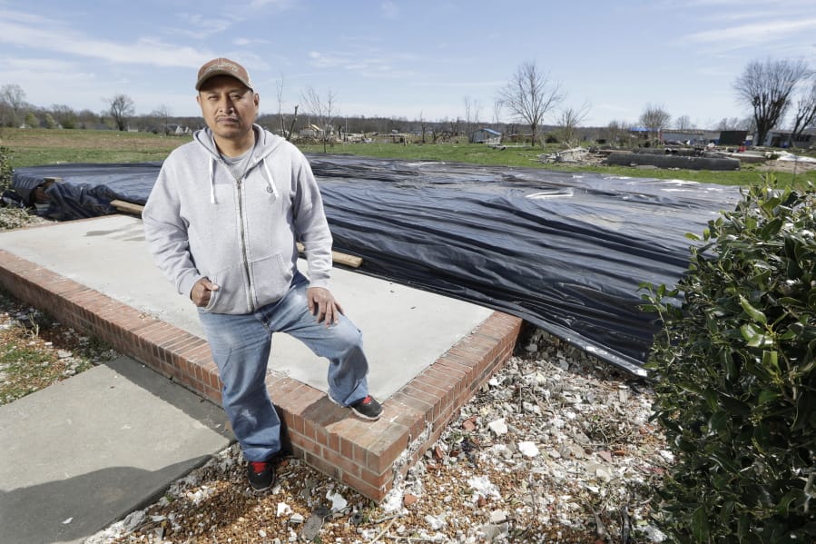 In this March 26, 2020, photo, Jose Cojom stands on the front step of what remains of his home after it was destroyed by a tornado in Cookeville, Tenn. Like thousands of other Middle Tennesseans, Cojom&#039;s life has been upended by back-to-back disasters. Residents still reeling from the deadly twisters of March 3 now have to confront life in the age of coronavirus.