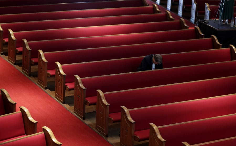 A man prays while attending an Easter service at Trinity Baptist Church in San Antonio, Sunday, April 12, 2020. Many churches are adapting their services as Christians around the world are celebrating Easter at a distance due to the COVID-19 pandemic.