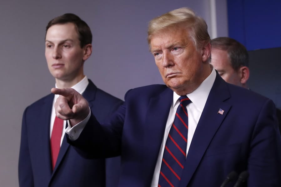 President Donald Trump points to a reporter to ask a question as he speaks about the coronavirus in the James Brady Press Briefing Room of the White House, Thursday, April 2, 2020, in Washington, as White House adviser Jared Kushner listens.