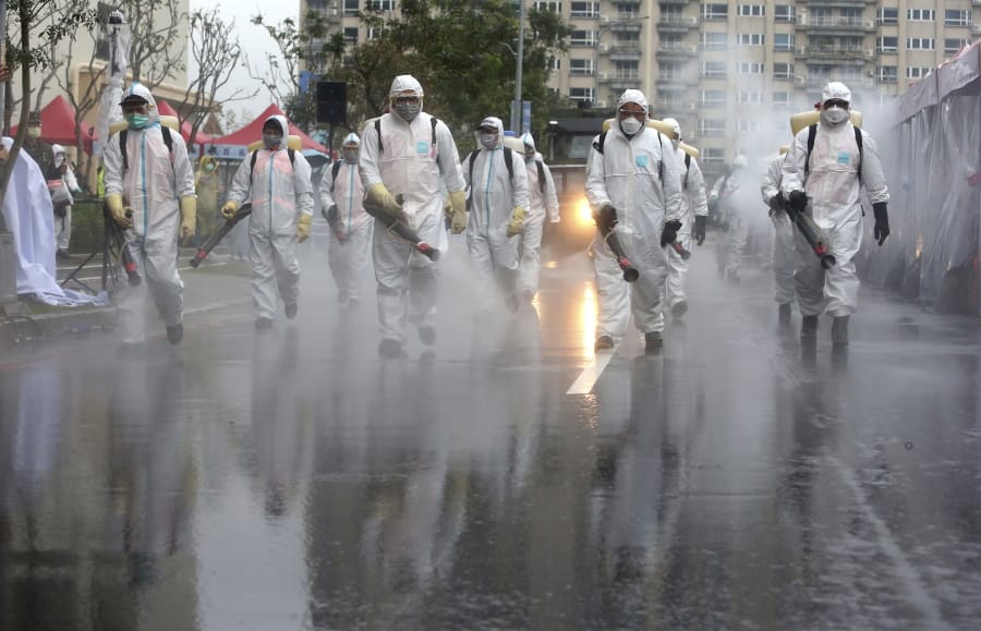 FILE - In this March 14, 2020, file photo Taiwanese army soldiers wearing protective suits spray disinfectant over a road during a drill to prevent community cluster infection of coronavirus in New Taipei City, Taiwan. The administration, backed by a bipartisan collection of lawmakers, is pressing for Taiwan&#039;s inclusion as a separate entity in international organizations like the World Health Organization and the International Civil Aviation Organization, both of which have significant roles in anti-virus efforts.