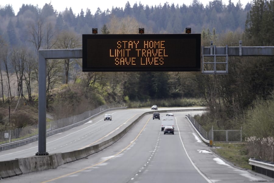 A sign overhead on an unusually quiet highway reminds drivers to &quot;Stay home, limit travel, save lives&quot; as part of Gov. Jay Inslee&#039;s ongoing stay-at-home order in the midst of the coronavirus outbreak, Wednesday, April 1, 2020, in Monroe, Wash.