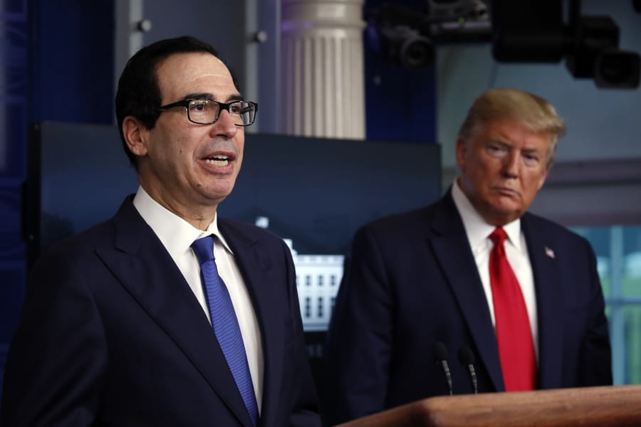 FILE - In this April 13, 2020, file photo President Donald Trump listens as Treasury Secretary Steven Mnuchin speaks about the coronavirus in the James Brady Press Briefing Room at the White House in Washington. The Trump administration and Congress are nearing an agreement as early as Sunday, April 19, on a $400-plus billion aid package to boost a small-business loan program that has run out of money and add funds for hospitals and COVID-19 testing.