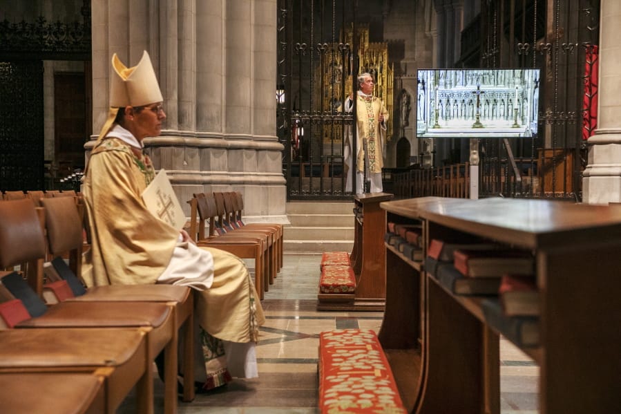 Rt. Rev. Mariann Edgar Budde, at left, Bishop of the Episcopal Diocese of Washington, and Very Rev. Randolph Marshall Hollerith, Dean of Washington National Cathedral, right, await their signal to begin a livestreamed Easter Sunday service at the National Cathedral with no parishioners, Sunday, April 12, 2020, in Washington, in light of coronavirus pandemic precautions. The large Cathedral would normally be full on Easter Sunday.