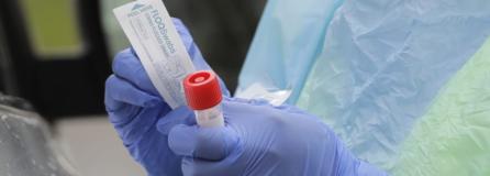 A nurse holds a vial and a swab at a drive-up coronavirus testing station in Seattle earlier this month. More options for testing are becoming available in Clark County. (Ted S.