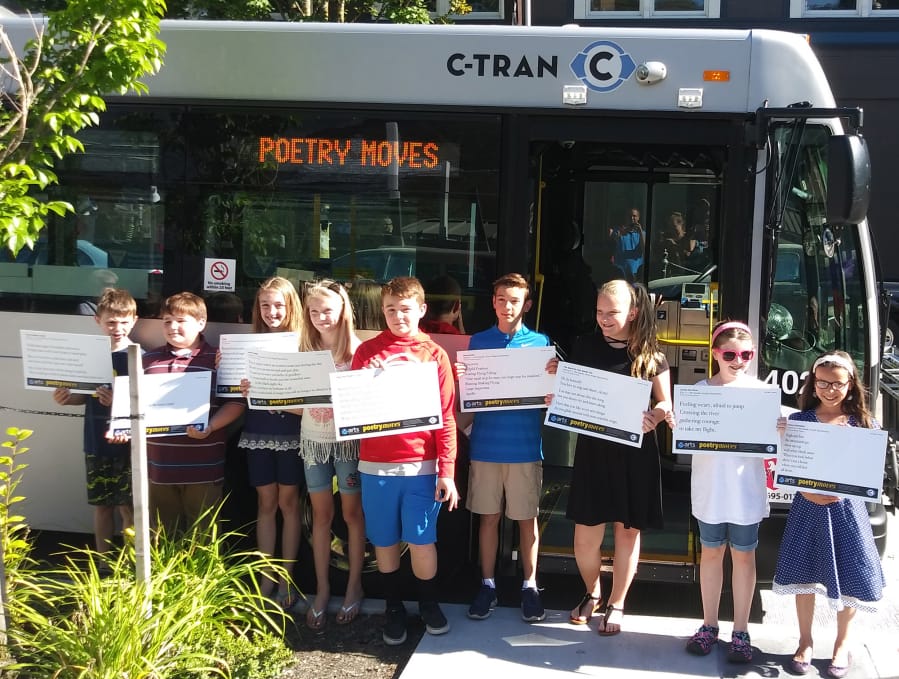 Past Poetry Moves winners in front of a C-Tran bus.