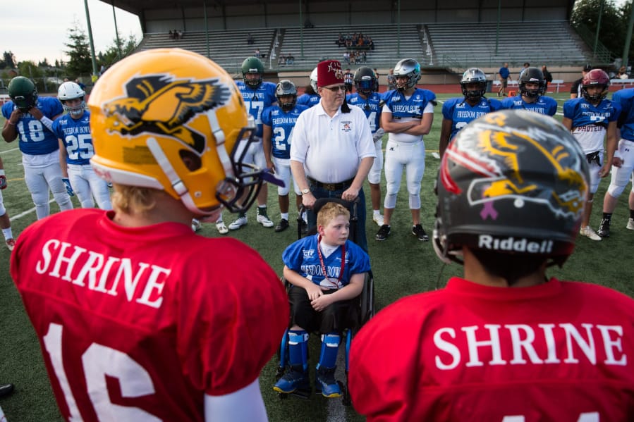 East All-Stars honorary captain Andrew Norton, 11, of Vancouver, is escorted by Shriner Bob Hitchcock, of Vancouver, for the coin toss before the start of the 2019 Freedom Bowl Classic at McKenzie Stadium. The 2020 game has been postponed until 2021 due to health concerns from the coronavirus pandemic.