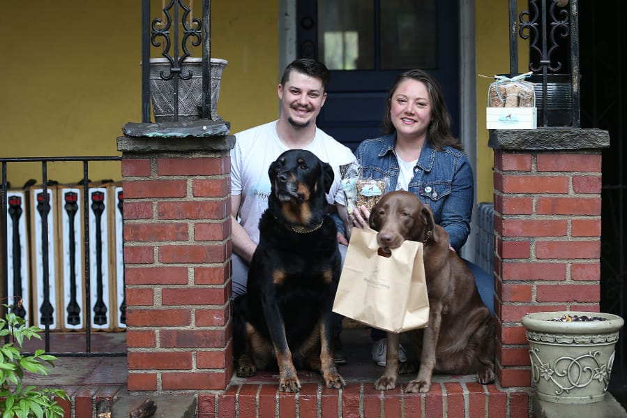 Chris Courter and Jennifer Kirby, who own and operate Piggyback Treats Company, pose for a portrait with their dogs Atlas, left, and Candy, right, outside their home in Philadelphia, PA on April 13, 2020.