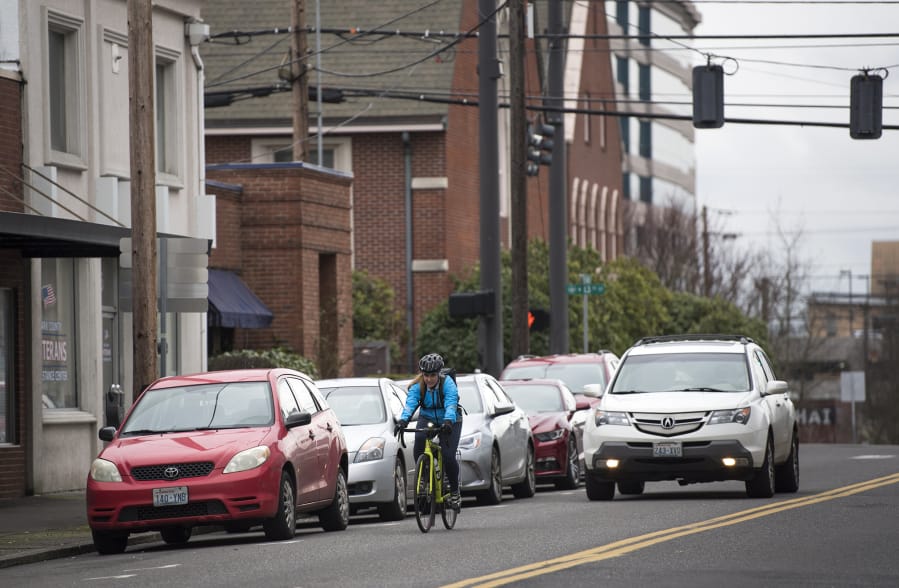 A cyclist rides along Columbia Street in February 2019. A project to remove street parking and add bike lanes has been postponed.