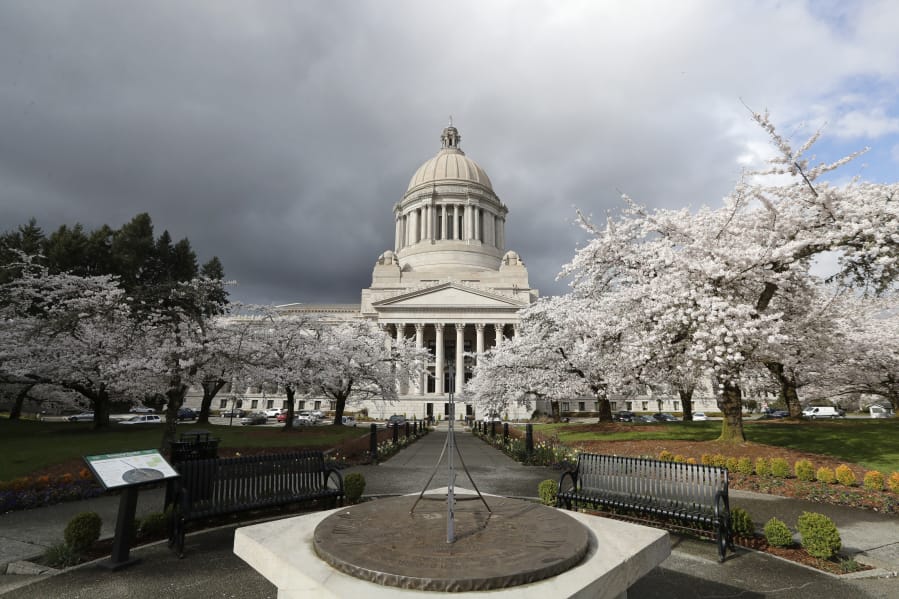 In this photo taken March 23, 2020, cherry trees bloom next to the Capitol building in Olympia, Wash.