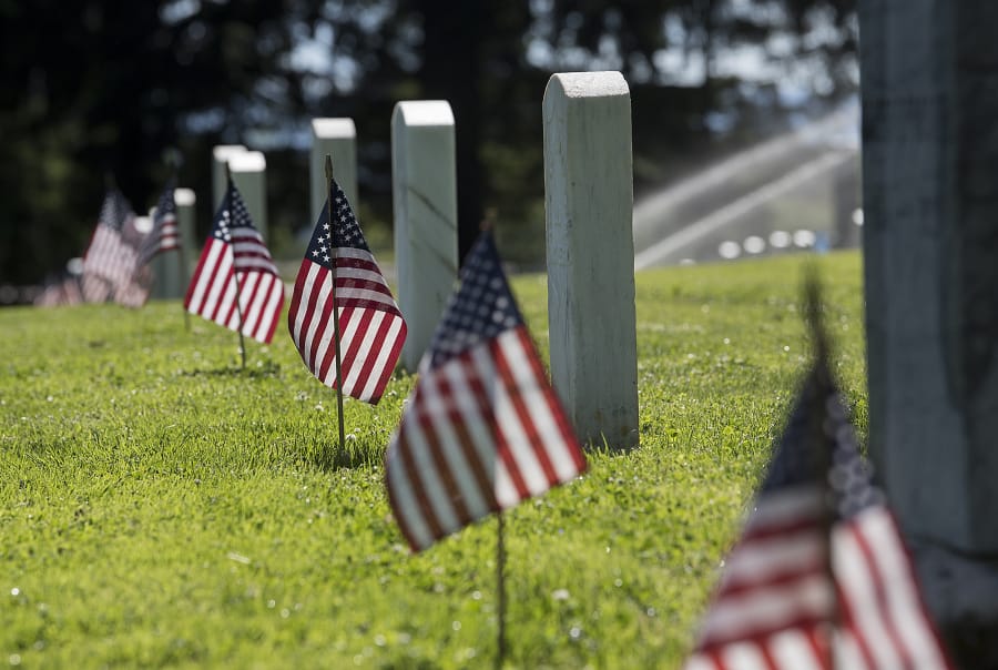 Afternoon sun illuminates American flags placed in preparation for Memorial Day at Vancouver Barracks Post Cemetery on May 23, 2019.