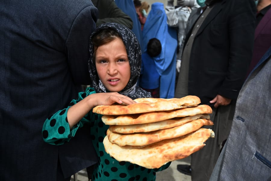 A young girl leaves after receiving free bread from the municipality outside a bakery during the Islamic holy month of Ramadan as government-imposed a nationwide lockdown as a preventive measure against the COVID-19 coronavirus, in Kabul on April 29, 2020.