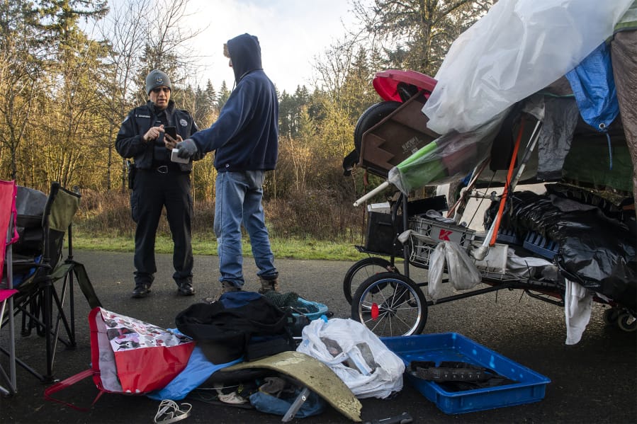 Tyler Chavers, Vancouver&#039;s homeless assistance response team officer, left, talks with Shawn Fernandez during the 2020 Point in Time count near Leverich Park on Jan. 30.