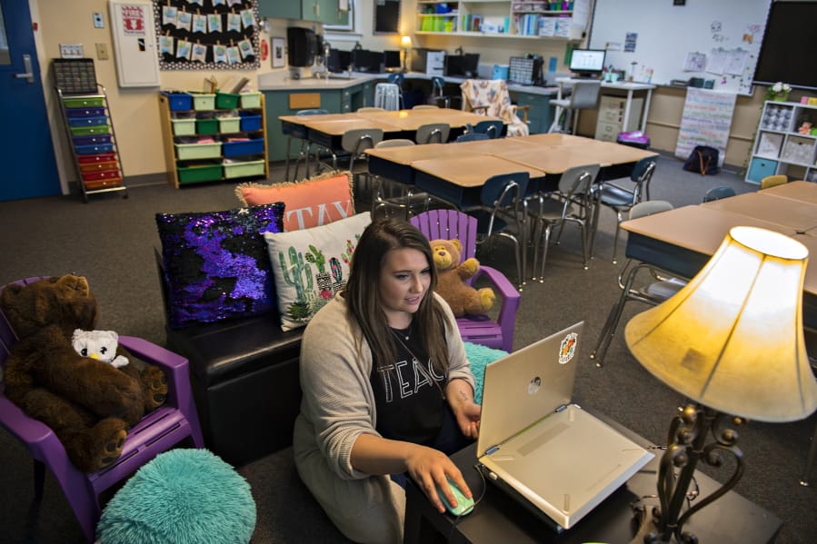 Second-grade teacher Nicole McClennen is joined by some furry friends as she records a lesson for her students on a laptop at Green Mountain School. McClennen said she tries to keep her video lessons familiar, and records them in her classroom&#039;s cozy reading corner.