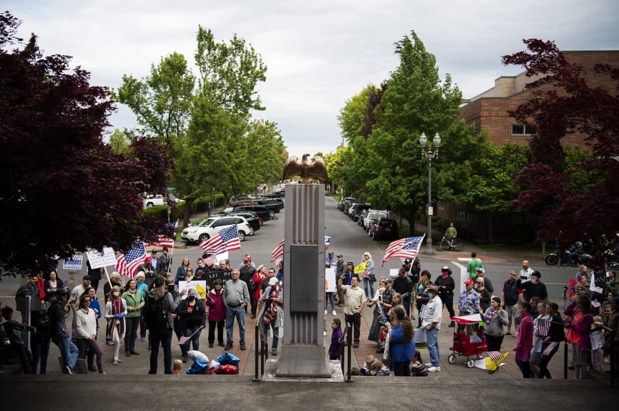 A crowd gathers in front of the Clark County Courthouse to protest Washington Gov. Jay Inslee&#039;s extension of coronavirus stay-at-home order in Vancouver on Friday.
