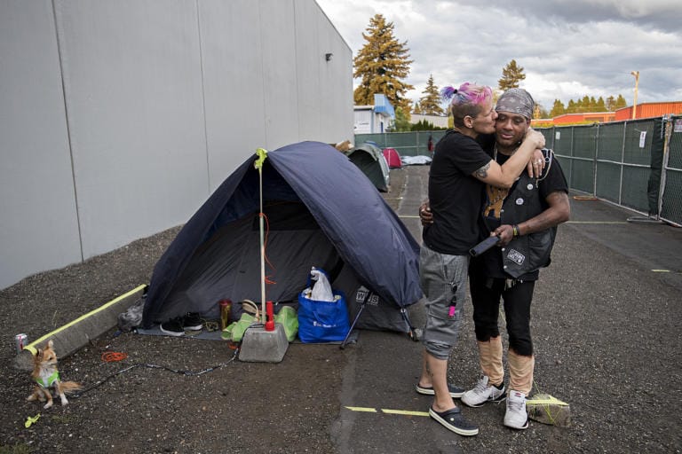 Mandi Holper, left, and Chris Winston share a quiet moment as they prepare to settle in for the night at the temporary homeless encampment outside Living Hope Church on Tuesday evening, May 5, 2020.