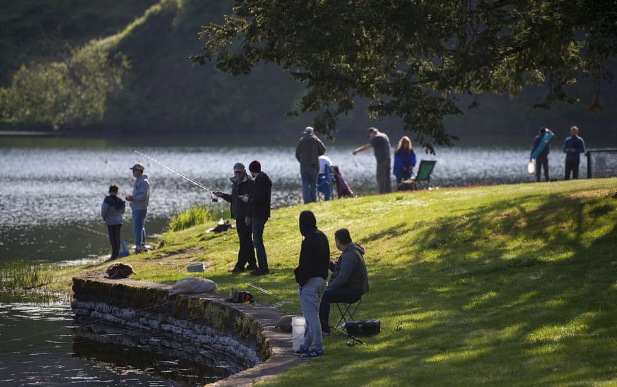 Fishing enthusiasts of all ages gather along the shoreline while keeping their distance at Klineline Pond in Salmon Creek on Tuesday morning. Tuesday was the first day fishing was allowed after Gov. Jay Inslee previously closed down the activity during the COVID-19 pandemic.