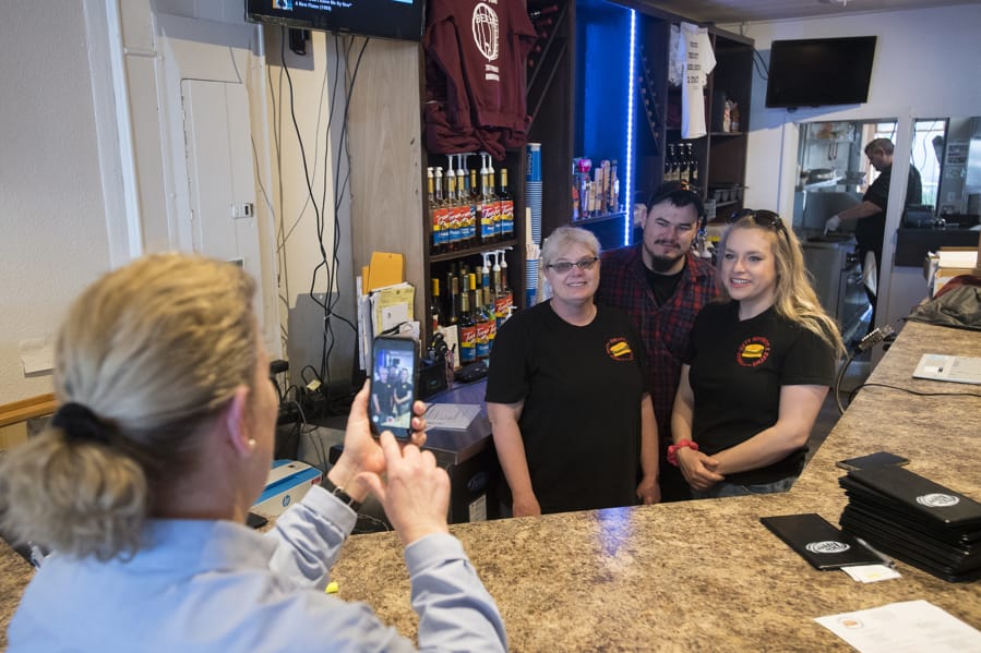 Marykay Lamoureaux, left, executive director of Ridgefield Main Street, records a video of Tammy Curlett, owner of Three-Sixty Burgers &amp; Brews, and her children, Robert and Breeanna Skeffington, on Friday afternooon as they encourage residents to shop locally.