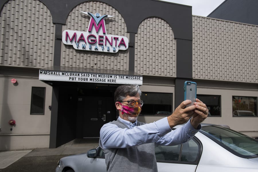 Sound technician Peter Wonderly wears a mask for safety as he snaps a selfie after putting the finishing touches on the front sign at the Magenta Theater in downtown Vancouver on Friday. Magenta Theater, which is dark during the COVID-19 pandemic, came up with the idea of renting out its Main Street marquee for community messages.