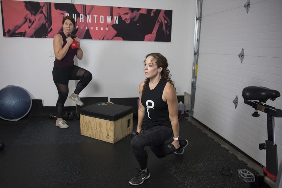 Coaches Barbara Laudadio, left, and Traci Cole of Burntown Fitness create a workout video for home users in their boss&#039;s garage.