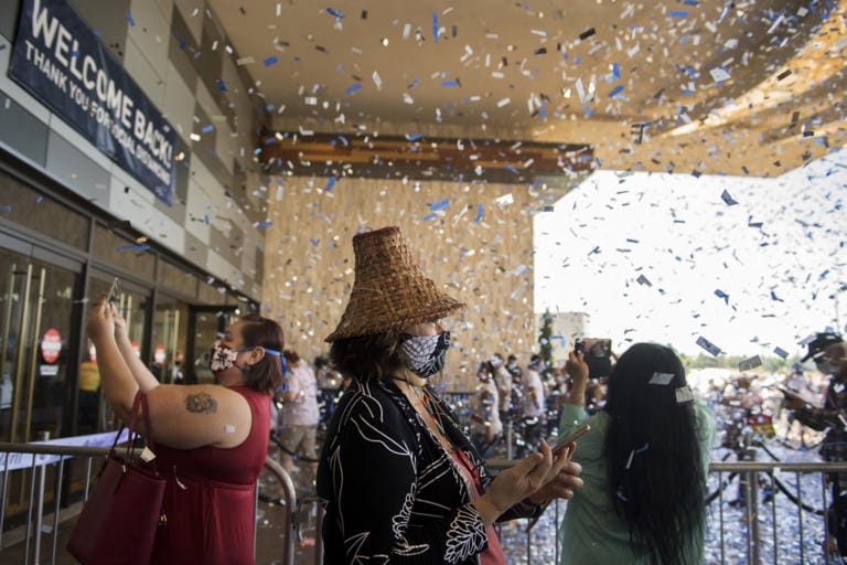 Katherine Vasquez, a Cowlitz Tribe councilwoman who lives Lacey, center, is surrounded by confetti as she celebrates the reopening of ilani Casino Resort with members of the public on Thursday morning, May 28, 2020. The casino has been closed for 70 days due to the COVID-19 pandemic. All guests are required to have their temperature checked upon arrival and to wear a mask.