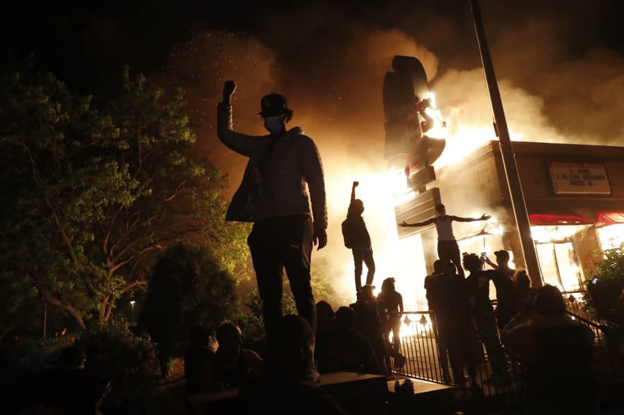 Protesters gather in front of a burning fast food restaurant Friday, May 29, 2020, in Minneapolis. Protests over the death of George Floyd, a black man who died in police custody Monday, broke out in Minneapolis for a third straight night.