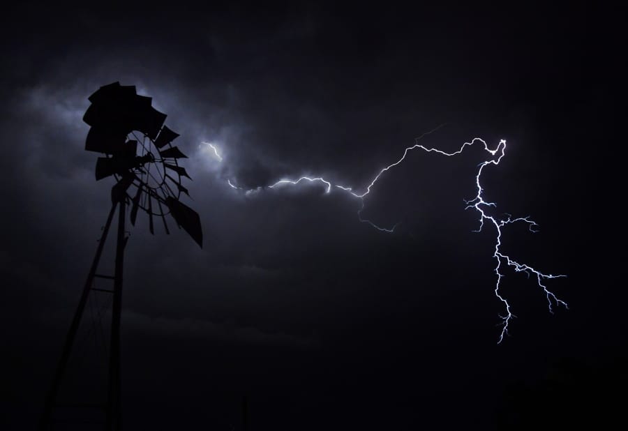 Lightning crackles across the sky above a windmill along the railroad tracks in Merkel, Texas, Thursday, May 21, 2020. More storms are predicted for Memorial Day weekend, and later into the week beyond. (Ronald W.