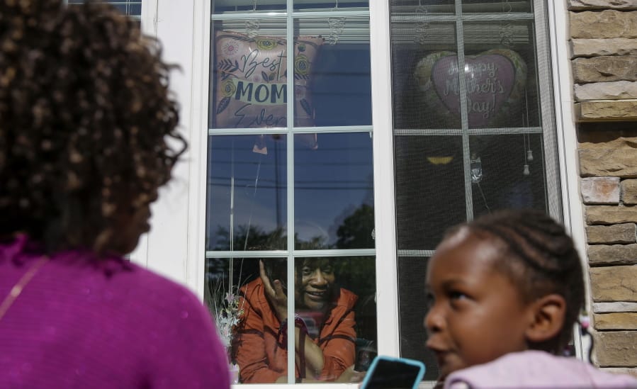 Mary Washington, 73, speaks through a window to her daughter, Courtney Crosby and grandchild Sydney Crosby for a Mother&#039;s Day celebration at Provident Village at Creekside senior living on Sunday, May 10, 2020, in Smyrna, Ga.