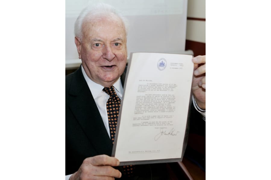 FILE - In this Nov. 7, 2005, file photo, former Australian Prime Minister Gough Whitlam holds up the original copy of his dismissal letter he received from then Governor-General Sir John Kerr on Nov. 11, 1975, at a book launch in Sydney, Australia. The High Court&#039;s majority decision in historian Jenny Hocking&#039;s appeal on Friday, May 29, 2020 overturned lower court rulings that more than 200 letters between the monarch of Britain and Australia and Governor-General Sir John Kerr before he dismissed Prime Minister Gough Whitlam&#039;s government were personal and might never be made public.