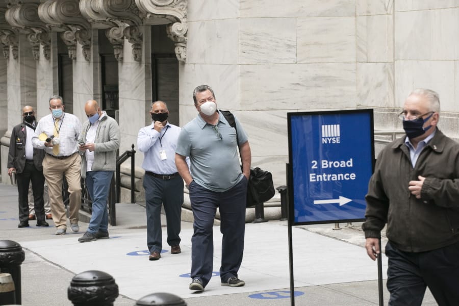 New York Stock Exchange employees wait to enter the building as the trading floor partially reopens, Tuesday, May 26, 2020.