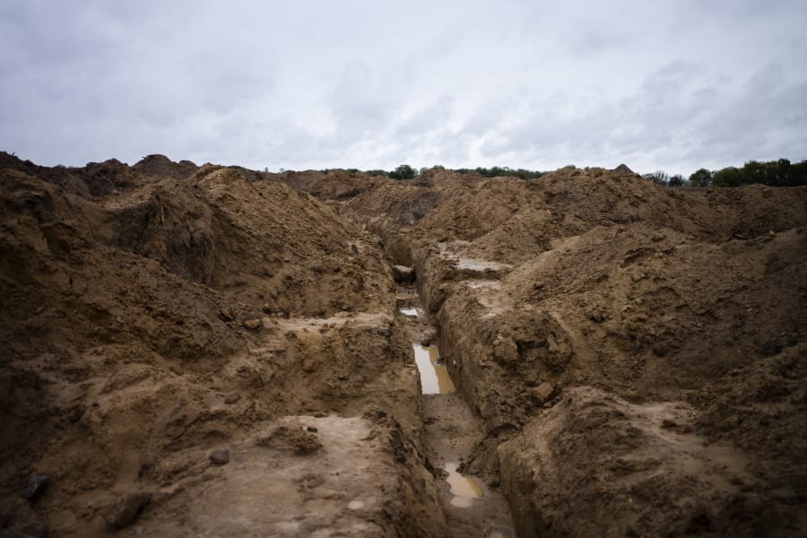 In this Wednesday, Oct. 2, 2019 photo, long-buried trench lines and military positions are excavated to search for fallen WWII soldiers near the village of Klessin, Germany. In eastern Germany, today&#039;s verdant pastures were killing fields 75 years ago as the Soviet Red Army pushed toward the Nazi capital in the final weeks of World War Two. Volunteers from across Europe comb across the area looking for the remains of the thousands of missing soldiers, working from old maps and aerial photos to identify the trenches, foxholes and strongpoints where they could be buried. They strive to give the dead a proper burial, and wherever possible identify the remains to provide closure for families.