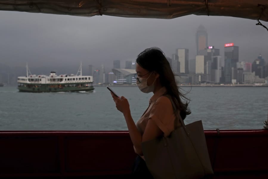 In this Thursday, May 28, 2020, photo, a woman uses a smartphone on a ferry in Hong Kong. Hong Kong has been living on borrowed time ever since the British made it a colony nearly 180 years ago, and all the more so after Beijing took control in 1997, granting it autonomous status. A national security law approved by China&#039;s legislature Thursday is a reminder that the city&#039;s special status is in the hands of Communist Party leaders who have spent decades building their own trade and financial centers to take Hong Kong&#039;s place.