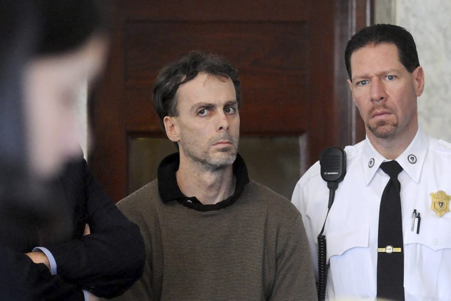 In this Jan. 29, 2009, photo, Sean Murphy, alleged mastermind behind a $2 million jewelry heist from the E.A. Dion jewelry manufacturing company in 2008, in Attleboro, Mass., listens to a list of charges brought against him during arraignment in Attleboro District Court. At right is court officer Howie Werman. In a February 2020 letter to The Associated Press, the career criminal said he is hoping to catch a break on his prison sentence from burglarizing a Brink&#039;s warehouse in Columbus, Ohio, during which he accidentally set millions of dollars on fire.