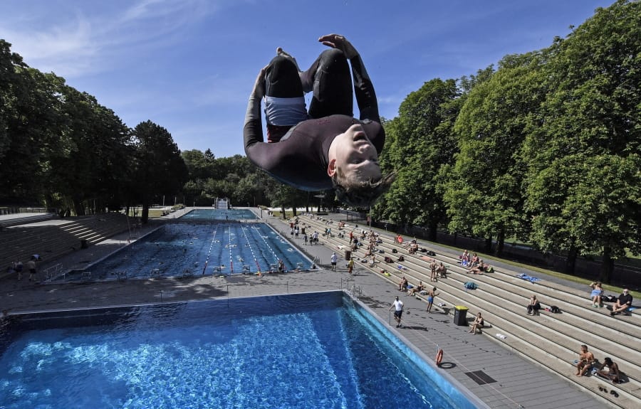 A swimmer jumps into the water May 21 during the opening day of the public open air pool in Cologne, Germany, on a warm and sunny day. Public swimming pools in Germany are starting the summer season as the government eases the coronavirus lockdown rules.