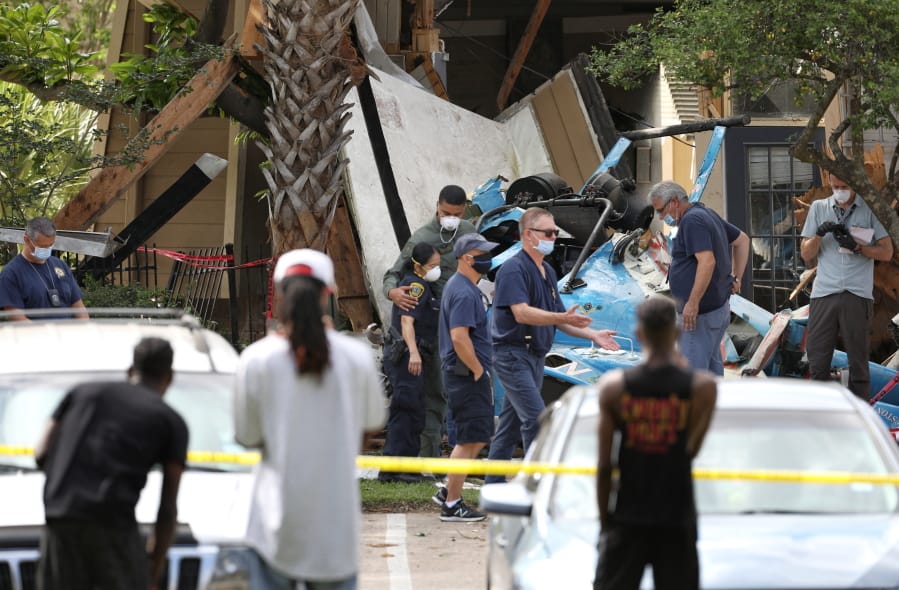 Authorities investigate the scene of a helicopter crash at an apartment complex in Houston,  Saturday, May 2, 2020.  Houston Police Chief Art Acevedo says the helicopter was carrying a pilot and a tactical flight officer when it went down at an apartment complex in north Houston around 2 a.m. Saturday.  The cause of the crash wasn&#039;t immediately known.