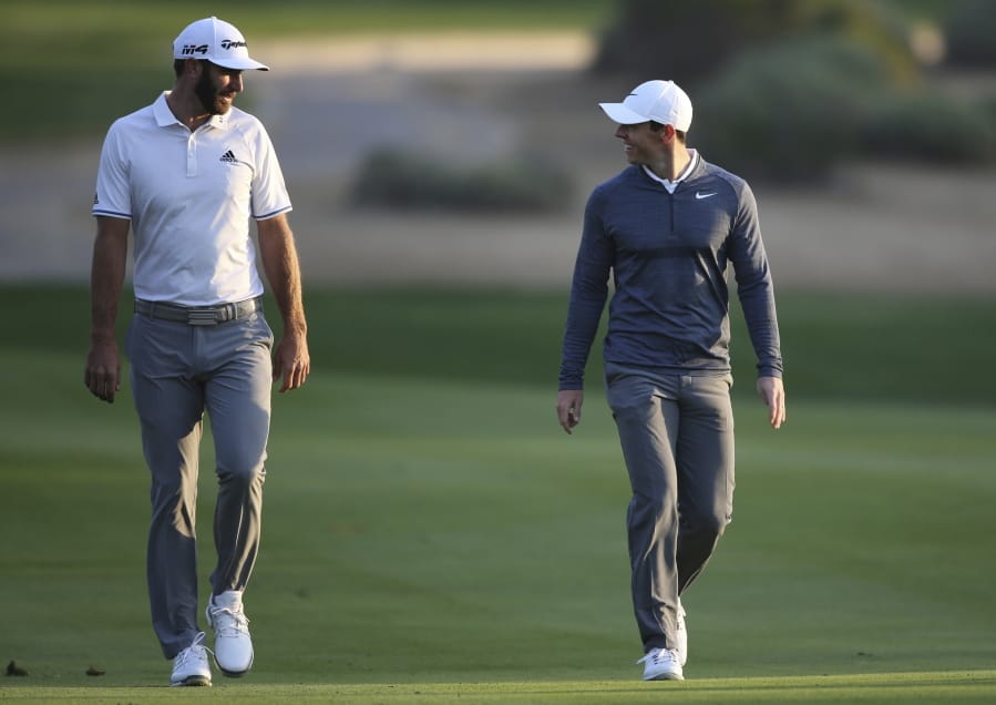 FILE - In this Jan. 18, 2018, file photo, Dustin Johnson of the United States, left, and Rory McIlroy of Northern Ireland talk on the 10th fairway during the first round of the Abu Dhabi Championship golf tournament in Abu Dhabi, United Arab Emirates. Dustin Johnson left The Players Championship two months ago and didn&#039;t play golf again until Sunday. He figured his game needed to be in shape for Rory McIlroy, his partner, in a charity match Sunday at Seminole that will be live golf&#039;s return to television.