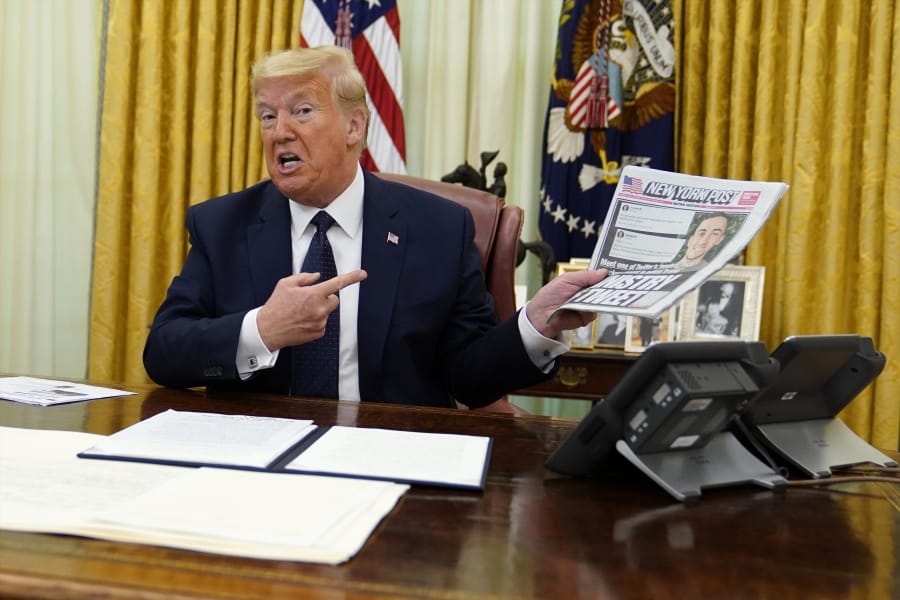 President Donald Trump holds up a copy of the New York Post as he speaks before signing an executive order aimed at curbing protections for social media giants, in the Oval Office of the White House, Thursday, May 28, 2020, in Washington.