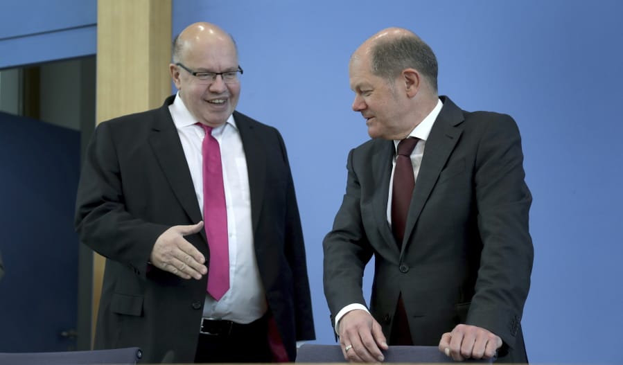 FILE - In this March 23, 2020 file photo, German Economy Minister, Peter Altmaier, left, tries to shake hands with German Finance Minister Olaf Scholz, right, prior to a press conference in Berlin, Germany. From the U.S. president to the British prime minister&#039;s top aide and far beyond, leading officials around the world are refusing to wear masks or breaking confinement rules meant to protect their populations from the coronavirus and slow the pandemic. While some are punished when they&#039;re caught, or publicly repent, others shrug off the violations as if the rules don&#039;t apply to them.