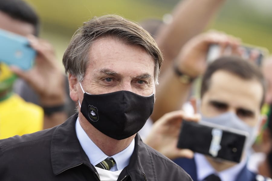 Brazil&#039;s President Jair Bolsonaro stands amid supporters taking pictures with cellphones as he leaves his residence of Alvorada palace in Brasilia, Brazil on Monday.